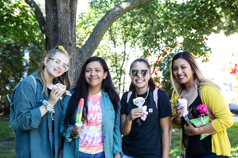 Four St. Kate's students smile with ice cream treats at the 2019 opening celebration picnic.