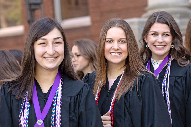 Three St. Catherine University graduates in academic garb