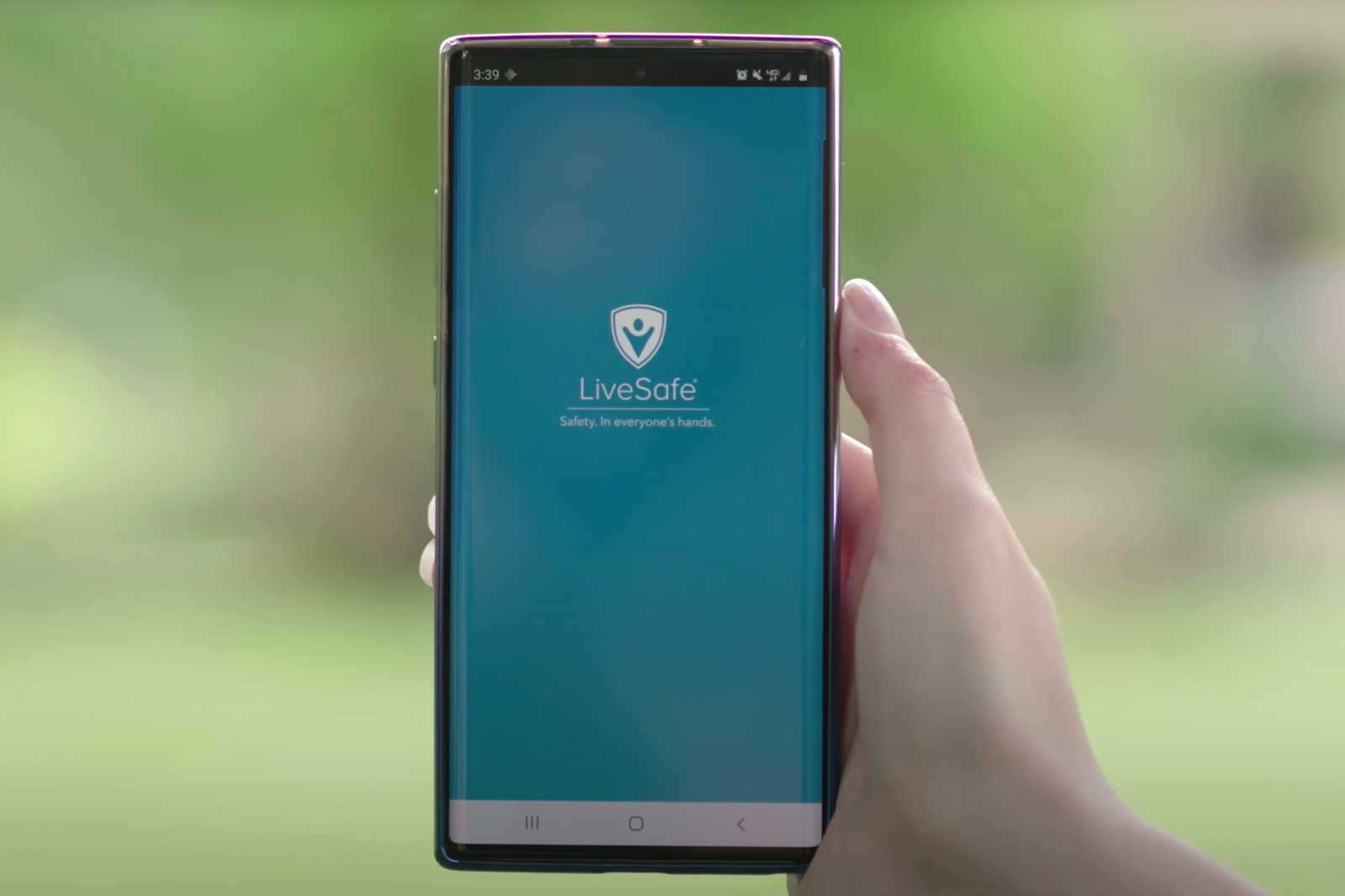 Picture of the St. Catherine University LifeSafe App on a smartphone, held by a hand on a blurred green background. Students, faculty, and staff submitted recommended changes to protect the community from intimate partner violence.