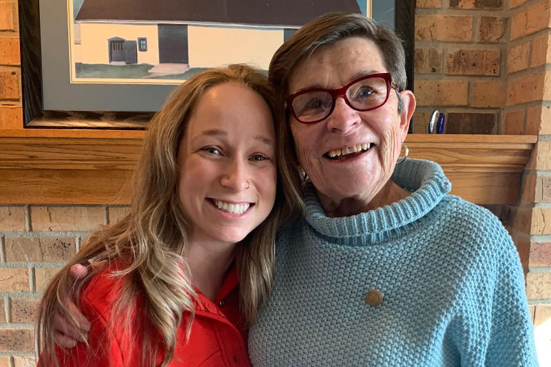 Megan Norby, MSN’21, RN, and GeorgAnn Burns ’57, smiling and in an embrace.
