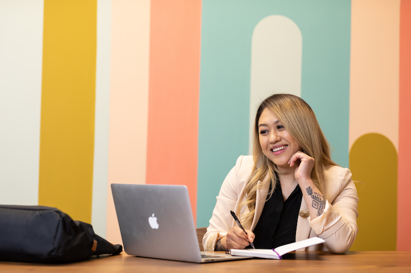 Student works at laptop in business attire, representing the marketing program in St. Kate's College for Adults