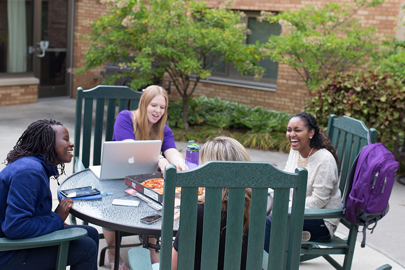 Students studying outside sharing pizza