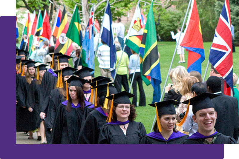 Graduates walking along world flag at graduation procession