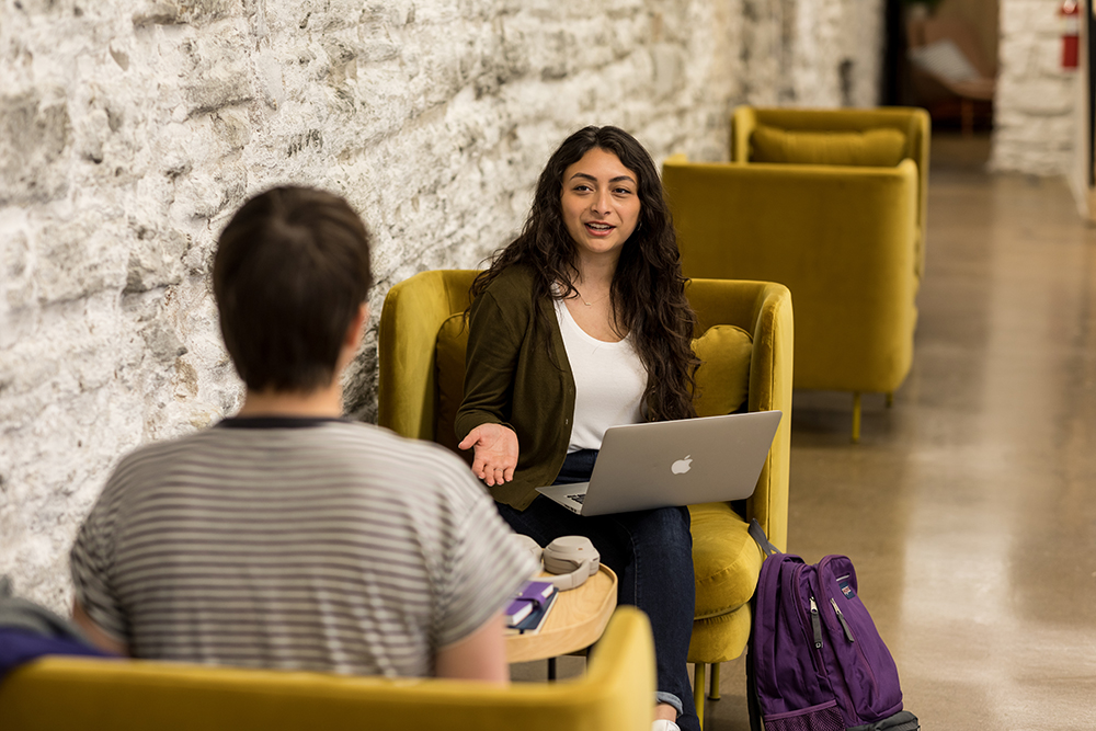 Communications student going over a project with another person