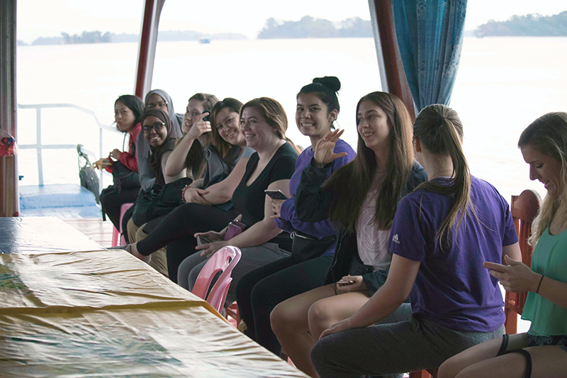 Line of students posing for photo on a boat while studying abroad