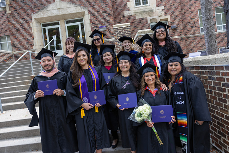 Male and Female College for Adult graduates posing for picture at graduation