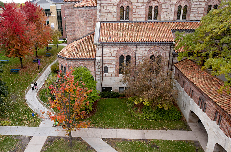 Overhead view of two students walking down path on campus