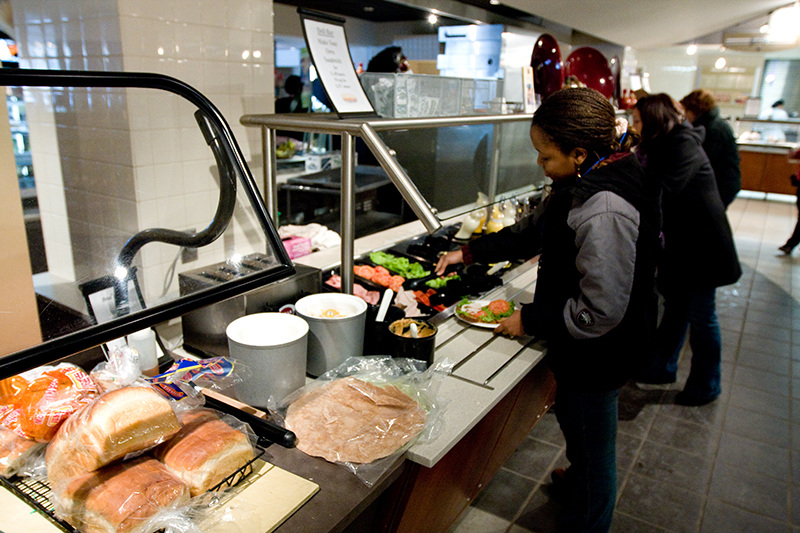 student getting salad at campus salad bar