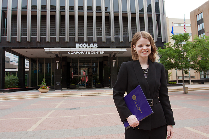 St. Kate's intern posing for picture in front of Ecolab's corporate headquarters