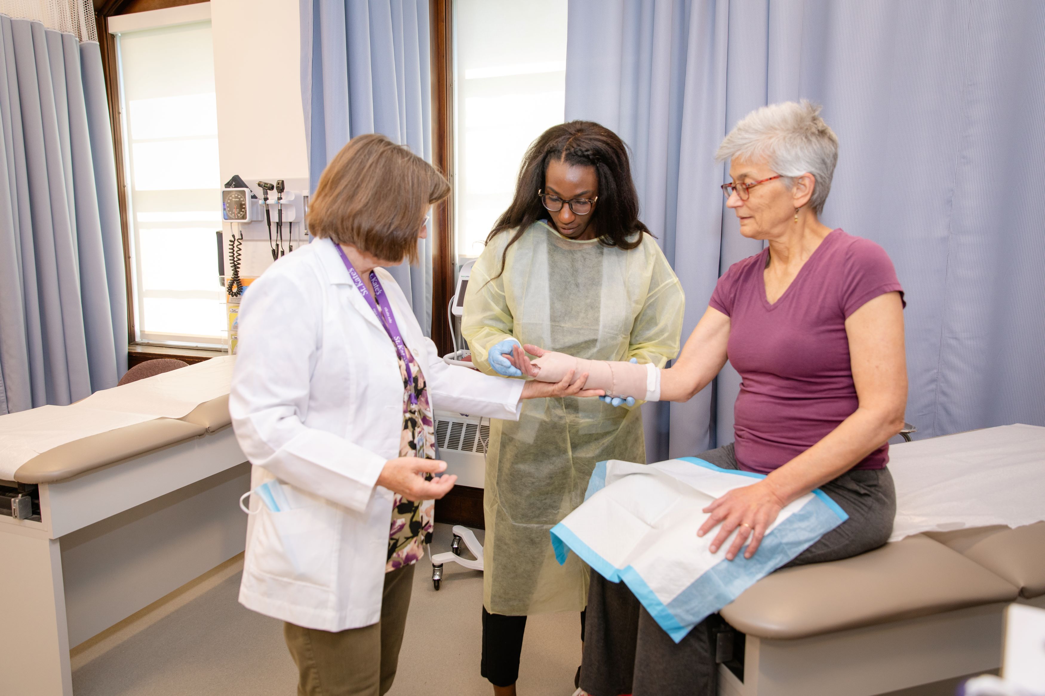 Patient receiving a cast on their wrist from a nursing instructor and student