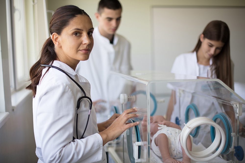 Neonatal nurse working with team in NICU