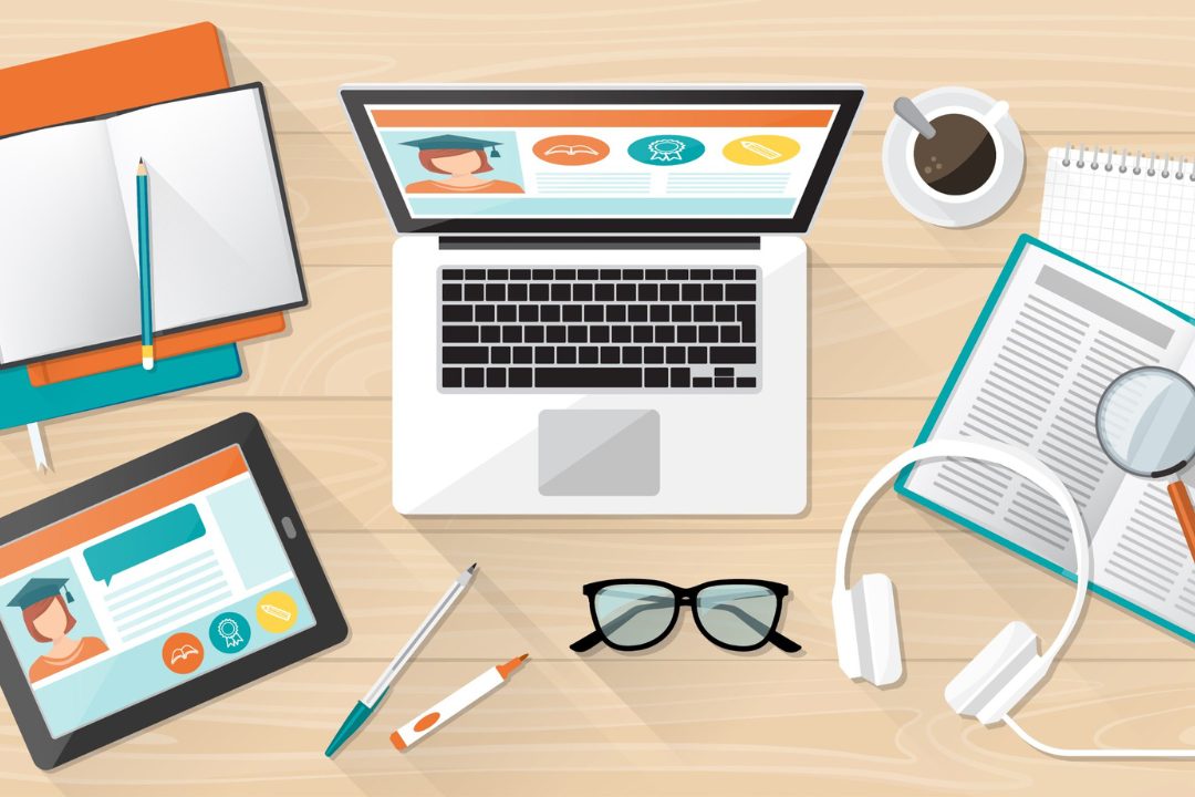 online learning graphic of a desk with a computer, paper, glasses, headphones.