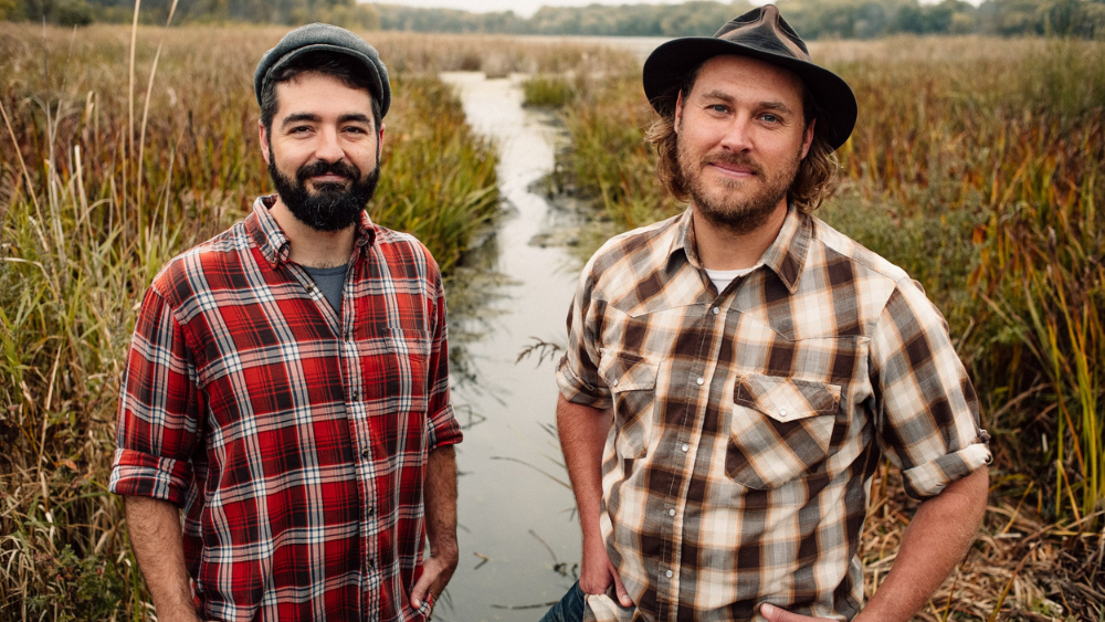 two men standing in a creek