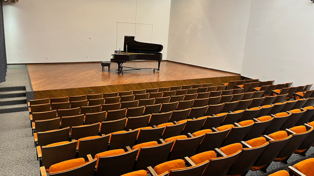 small recital hall with a piano on stage