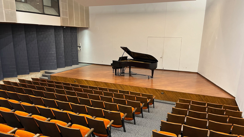 small recital hall with piano on stage