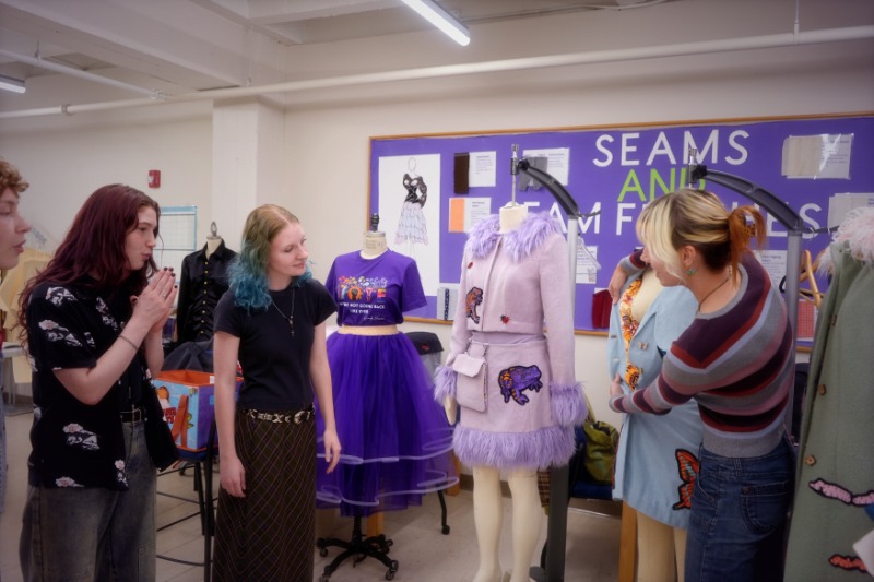 Fashion students huddled and discussing a current project