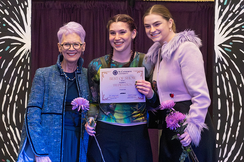 Professor and students posing for award ceremony at St.Kate's annual fashion show