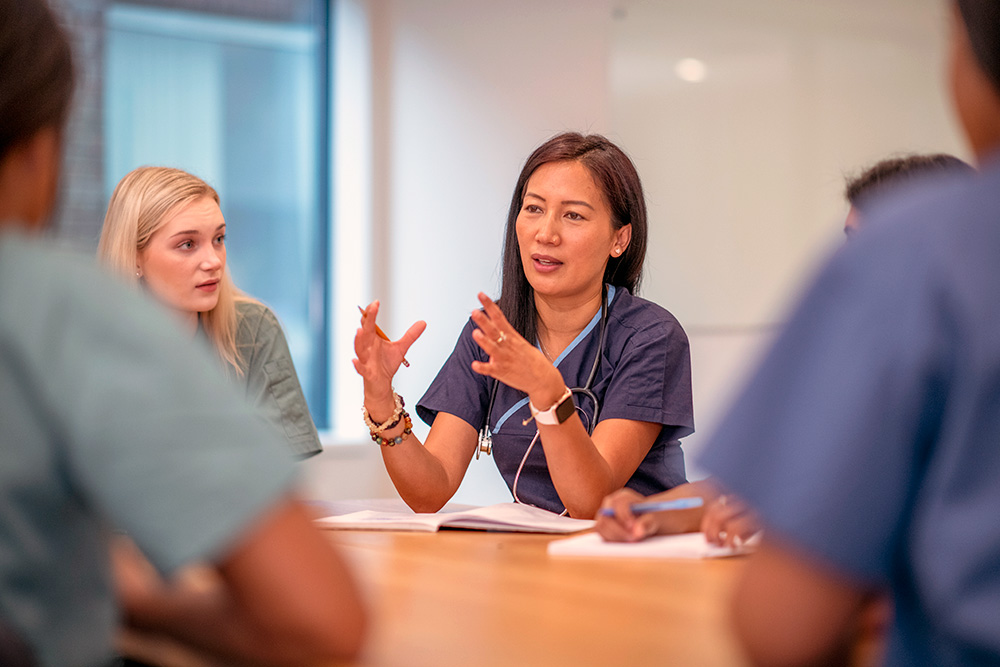 Nursing leader meeting with colleagues at conference table