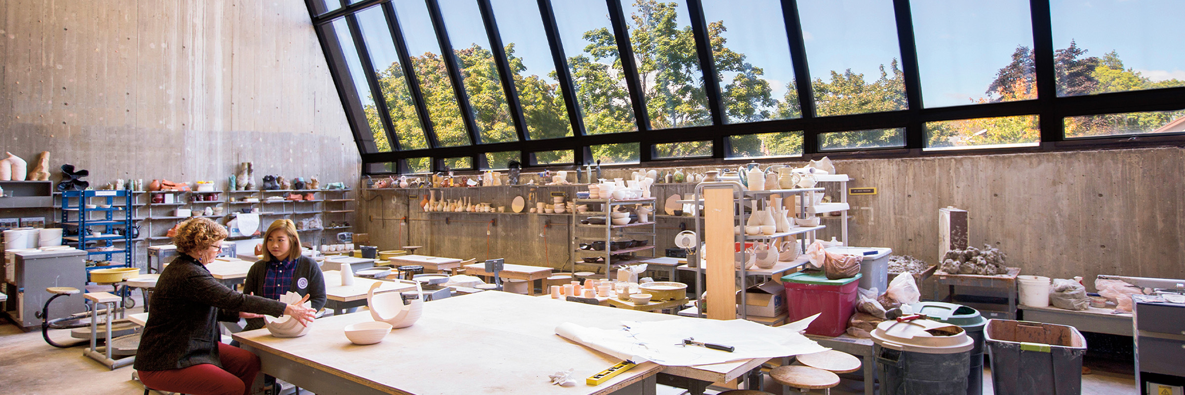 Facutly consulting with student over potter project in art studio
