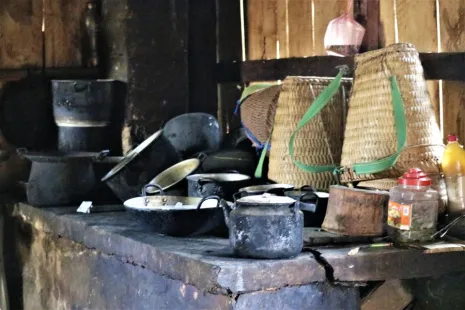 Pots, pans, and woven baskets used to carry crops home, piled on a counter