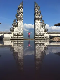 Student stands, arms outstretched in the Temple of Lempuyang, Indonesia
