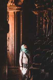 A student observes the beautiful intricate stone carvings on the inside of the Hindu temple dedicated to Shiva