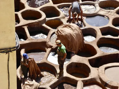 Men tanning animal hides in vats of dye