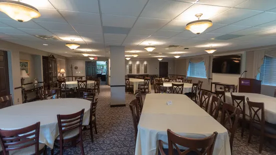 President's Dining Room from east side, view of tableclothed tables, tv screen, and seating areas