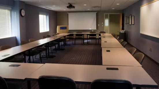 CdC Conference Room with tables in a circle and a podium and presentation screen at the front