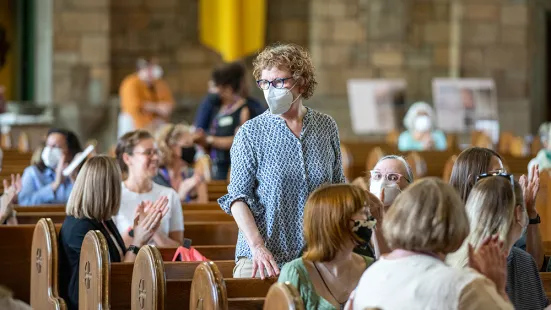 Faculty member stands for recognition in Our Lady of Victory Chapel