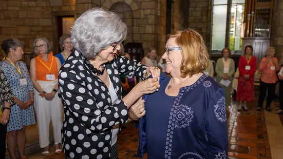 President Rebecca Koenig Roloff ’76 pins an alumna.