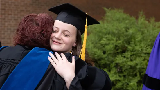 Graduate hugs faculty member