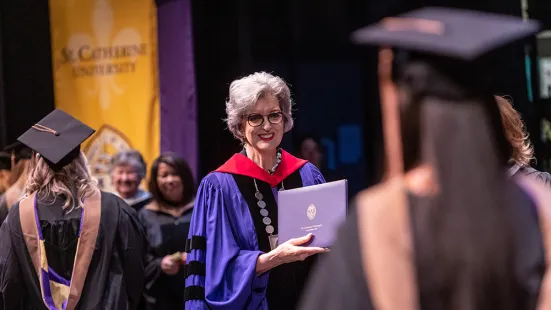President Roloff holds diploma for a new graduate