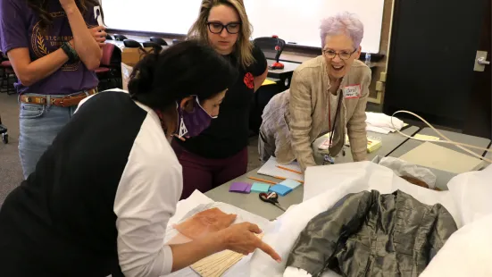 Professors and volunteers examining garments