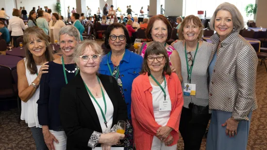 Smiling alumni pose with President Roloff '76 for a photo at Reunion