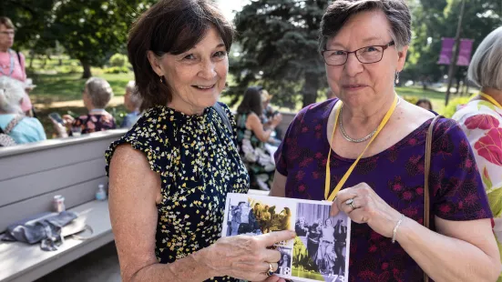 Alumni hold up a picture of themselves from their time at St. Kate's