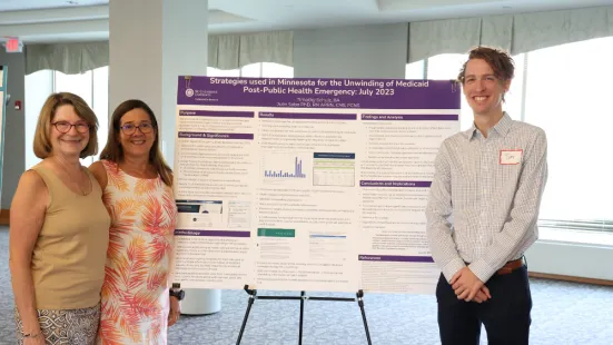 Students and faculty researchers stand in front of their poster. 
