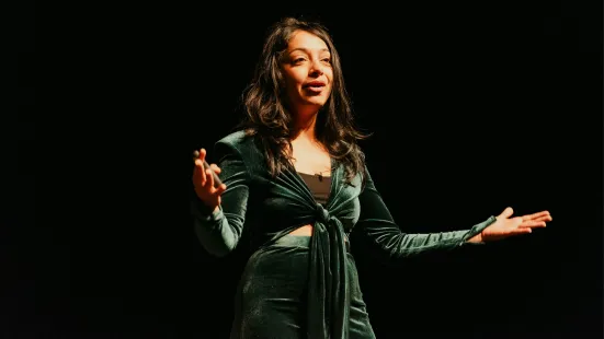 Radhika Dirks gestures on stage during her presentation.