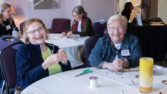 Two women seated and laughing