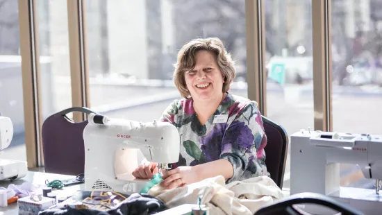 Woman sewing and smiling