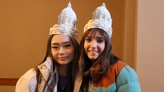 Students wear paper hats in the shape of the Capitol building
