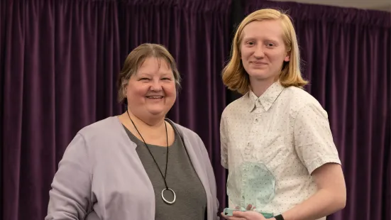 A student poses with their award. 