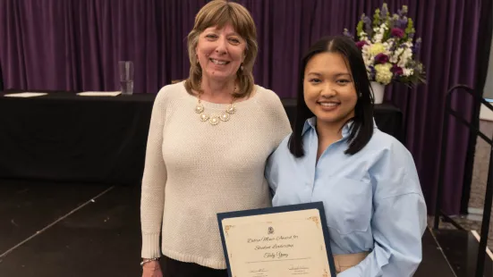 A student poses with their award