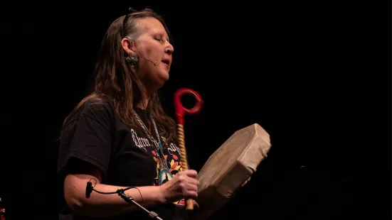 Lyz Jaakola plays a hand drum on stage at The O'Shaughnessy