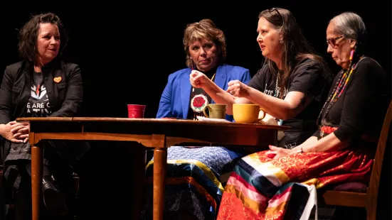 The Aunties storytellers sit around a table on stage for a Q&A session