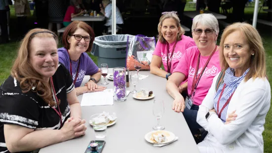 A group of women sit around a picnic table.