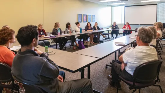 People sit around tables in a conference room