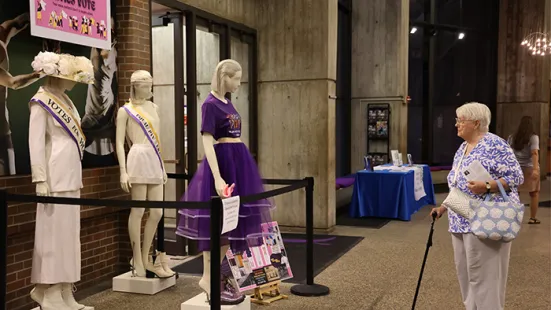 Community member looking at fashion designs in the lobby.