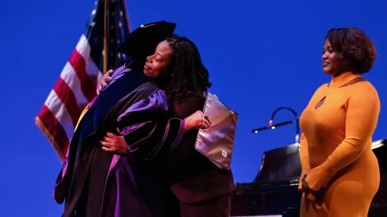 President Evans hugs her daughters on stage