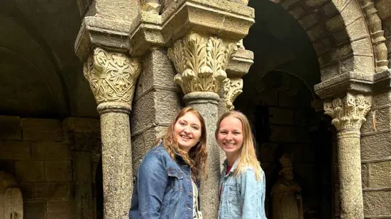Two alumnae standing in front of columns in a cathedral.